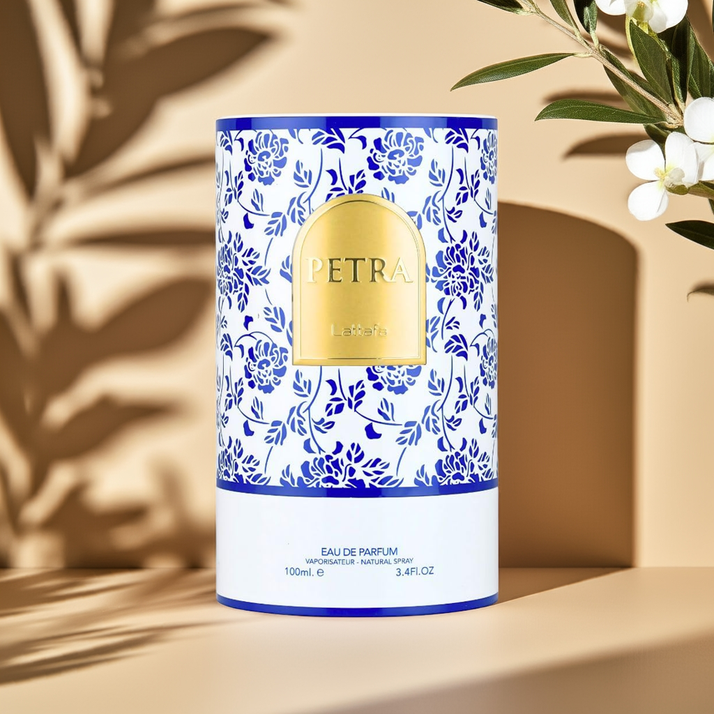 Lattafa Petra Eau de Parfum packaging featuring a blue floral design and gold label, highlighting its sun-kissed, creamy coconut and vanilla aroma.