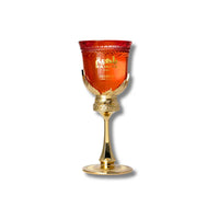 Close-up of Bahiya Ruby perfume with elegant gold stand and red glass